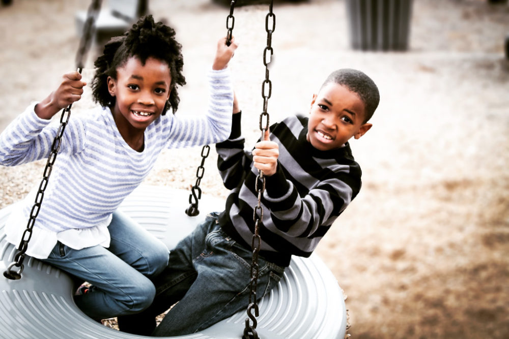 2 kids on a swing