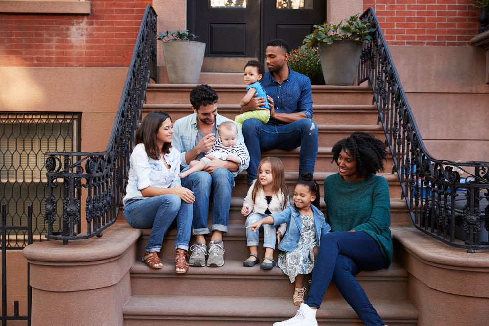 2 Families sitting on front stoops