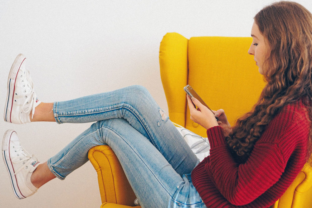 Teen girl on chair looking at phone