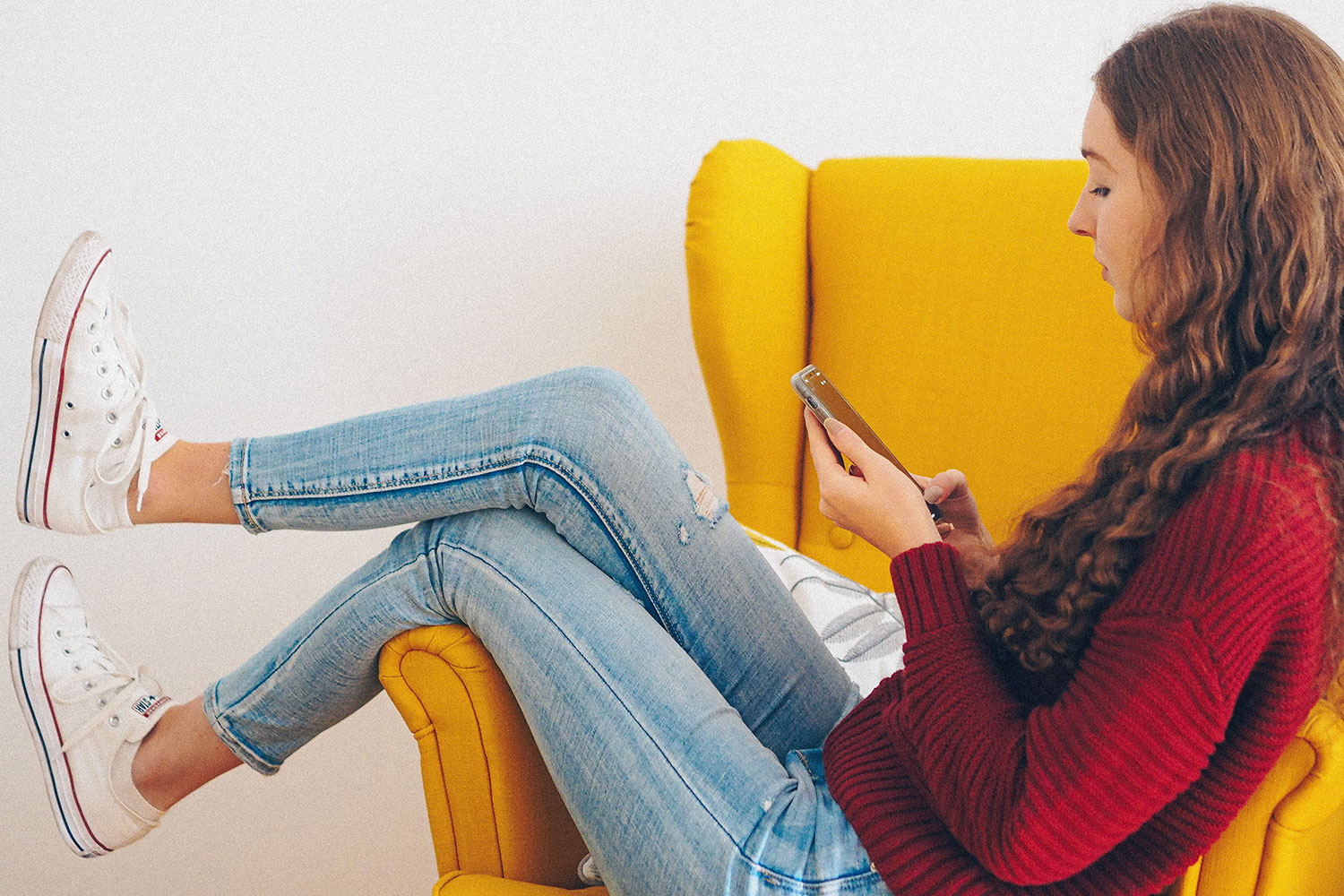 Teen girl on chair looking at phone